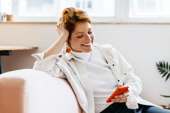 female-european-adult-indoor-smiling-while-using-smartphone-at-home-web